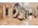 Elegant foyer featuring high ceilings, tile floors, and a staircase with black iron railings at 18963 E Long Ave, Centennial, CO 80016