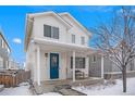 Two-story house with blue door, snowy porch, and trees at 4715 Crestone Peak St, Brighton, CO 80601