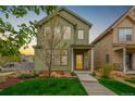 Charming two-story home with a vibrant green exterior, yellow door, covered porch, and well-manicured lawn at 1754 W 66Th Ave, Denver, CO 80221
