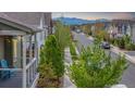 Neighborhood street view with well-maintained homes, mature trees, and mountain views in the distance at 1754 W 66Th Ave, Denver, CO 80221