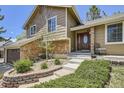 Close up of the front entrance with a stone wall, decorative landscaping and a beautiful front door at 1973 S Pitkin St, Aurora, CO 80013