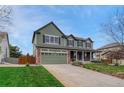 Inviting two-story home with a brick-accented facade, covered porch, attached garage, and a green lawn in a suburban setting at 22021 Pebble Brook Ln, Parker, CO 80138