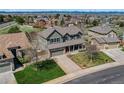 Attractive two-story home with a charming front porch, green lawn, and an attached garage at 22021 Pebble Brook Ln, Parker, CO 80138