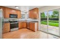 Bright kitchen features stainless steel appliances, wood cabinets, and sliding glass door to the backyard patio at 5262 E Sandpiper Ave, Castle Rock, CO 80104