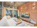 Stylish living room with exposed brick wall, wood floors, modern lighting, and a comfortable sectional at 1720 Wazee St # 2B, Denver, CO 80202