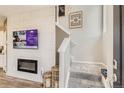 Entryway with tiled accent wall, modern fireplace, stairs and grey carpet floors at 6807 Huddersfield Ln, Castle Pines, CO 80108