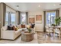 Bright living room with neutral decor, large windows, and stylish furnishings at 6807 Huddersfield Ln, Castle Pines, CO 80108