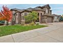 Charming two-story house with stone accents, green lawn, and lovely landscaping at 14022 E Fair Pl, Centennial, CO 80111