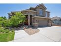 Charming home featuring a stone and brown exterior, well-manicured landscaping, and attached garage at 14022 E Fair Pl, Centennial, CO 80111