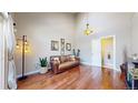 Open-concept living room with vaulted ceilings, hardwood floors, and stylish decor with a staircase view at 1381 W 112Th Ave # B, Westminster, CO 80234