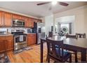 Eat-in kitchen features stainless steel appliances, wood cabinets and hardwood floors at 4151 S Lewiston Cir, Aurora, CO 80013