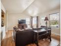 A naturally lit living room with hardwood floors and a large sectional couch at 4151 S Lewiston Cir, Aurora, CO 80013