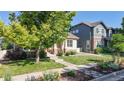 Charming home with a welcoming front porch, lush landscaping, and a vibrant green lawn at 14230 Lakeview Ln, Broomfield, CO 80023