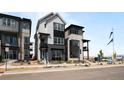 Modern three-story home featuring gray and black siding, stone accents, and well-manicured landscaping at 1793 W 166Th Ave, Broomfield, CO 80023