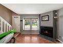 Cozy living room featuring a fireplace, wood floors, and large double windows at 16901 E Chenango Ave # E, Aurora, CO 80015