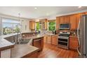 Bright kitchen featuring stainless steel appliances, wood cabinets, and hardwood flooring at 641 Briar Haven Dr, Castle Pines, CO 80108