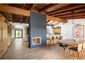Open-concept living room and kitchen with hardwood floors, modern fireplace and exposed beams at 2060 Hoyt St, Lakewood, CO 80215
