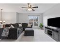 Inviting living room with gray sectional sofa, ceiling fan, a window and modern entertainment center at 11338 Donley Dr, Parker, CO 80138