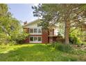 Two-story red brick home with a well-maintained lawn and established trees at 7475 W Vassar Ave, Lakewood, CO 80227