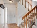 Inviting entryway featuring tile flooring, a coat rack, and a staircase with wooden banister at 8394 S Everett Way # E, Littleton, CO 80128