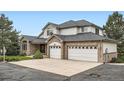 Attractive two-story home features a brick facade, an attached three-car garage, and well maintained landscaping at 6335 Oberon Rd, Arvada, CO 80004