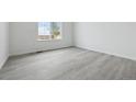 Bright, empty bedroom with wood-look floors, a large window, and freshly painted white walls at 25234 E Warren Pl, Aurora, CO 80018