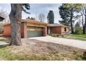 Charming home with a green garage door, brick accents, and a mature tree in the front yard at 404 S Oneida Way, Denver, CO 80224
