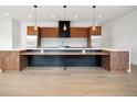 Spacious kitchen featuring stainless appliances, walnut cabinetry, white countertops, and statement lighting at 5224 Lions Paw St, Castle Rock, CO 80104