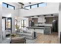 Open-concept living area flows into modern kitchen with stainless steel appliances, island, and ample counter space at 5224 Lions Paw St, Castle Rock, CO 80104