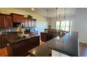 Spacious kitchen features dark wood cabinets, granite countertops, and stainless steel appliances at 16699 Las Brisas Dr, Broomfield, CO 80023