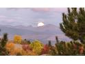 Scenic mountain view with colorful fall foliage and the moon setting behind the distant peaks at 16699 Las Brisas Dr, Broomfield, CO 80023