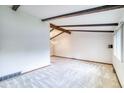 An open-concept living room with exposed wood beam and neutral carpeting at 2621 S Kingston Ct, Aurora, CO 80014