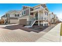 Beautiful two-story home featuring a two-car garage, brick driveway, and inviting front porch at 10136 Yampa Ct, Commerce City, CO 80022