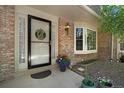 Inviting front porch with brick facade, bay window, and decorative flower pots create a warm welcome at 7557 S Cove Cir, Centennial, CO 80122