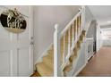 Entryway with a carpeted staircase and white railing, leading to the upper levels of the home at 7557 S Cove Cir, Centennial, CO 80122