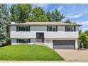 Well-maintained two-story home with a manicured front lawn and gray door at 10863 W 67Th Pl, Arvada, CO 80004