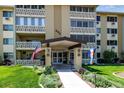 Inviting condo building showcasing professional landscaping, flags, and a covered entryway at 695 S Alton Way # 5A, Denver, CO 80247