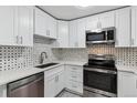 Bright kitchen boasts stainless steel appliances, a modern sink, and sleek white cabinets at 695 S Alton Way # 5A, Denver, CO 80247