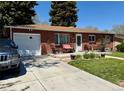 Charming brick ranch-style home featuring a well-manicured front yard and long driveway at 2213 S Meade Street, Denver, CO 80219
