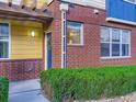 Townhouse exterior with brick accents, a wreath on the front door, and manicured shrubbery at 11316 Colony Cir, Broomfield, CO 80021