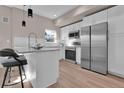 Stylish kitchen with stainless steel appliances, white cabinets, island, and sleek countertops at 2140 S Ash St # 104, Denver, CO 80222