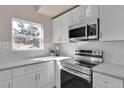 Well-lit kitchen showcases stainless steel appliances, white cabinets, and modern tile backsplash at 2140 S Ash St # 104, Denver, CO 80222