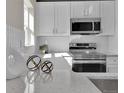 Bright kitchen featuring white cabinetry, stainless steel appliances, and elegant countertops at 2140 S Ash St # 104, Denver, CO 80222