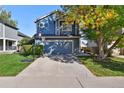 Two-story blue home with a two-car garage and basketball hoop at 11220 Keota St, Parker, CO 80134