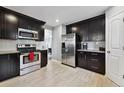 Modern kitchen with stainless steel appliances and dark cabinetry at 11220 Keota St, Parker, CO 80134