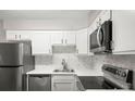 Bright kitchen featuring white cabinets, stainless steel appliances, and modern countertops at 3663 S Sheridan Blvd # 2, Denver, CO 80235
