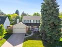 A lovely two-story home featuring a well-maintained lawn, mature trees, and a welcoming front porch at 6829 S Niagara Ct, Centennial, CO 80112