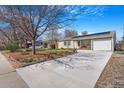 Inviting single-story home with a long driveway and blooming trees at 5085 E Missouri Ave, Denver, CO 80246