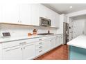 Modern kitchen with white cabinets, stainless steel appliances, and a stylish backsplash at 5253 Cherry Blossom Dr, Brighton, CO 80601