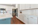 Open kitchen with white cabinetry, stainless steel appliances, and a large island with a sink at 5253 Cherry Blossom Dr, Brighton, CO 80601